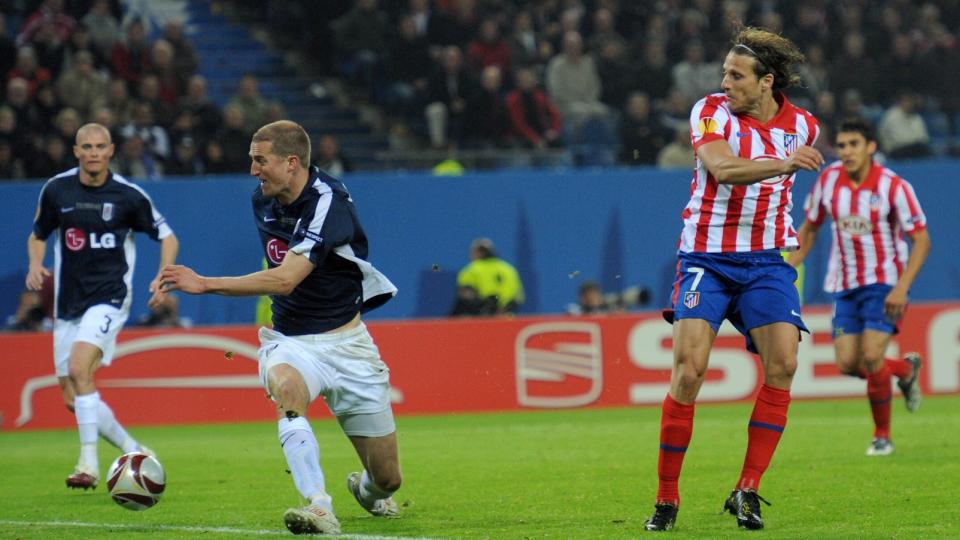 VIA BREDE: Diego Forlan snek seg inn foran Brede Hangeland og satte inn det avgj�rende m�let via l�ret til den norske landslagskapteinen. Dermed vant Atletico Madrid kveldens Europa League-finale 2-1 mot Fulham etter ekstraomganger. Foto: Marcus Brandt, EPA/Scanpix