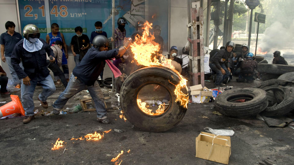 GATEKAMPER:  En demonstrant sender et brennende hjul i retning oppr�rsstyrkene i Bangkok. De siste dagers voldsb�lge har kostet 22 mennesker livet. Foto: AFP PHOTO/PEDRO UGARTE