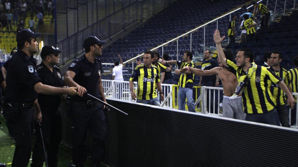 RASENDE: Feststemte Fenerbahce-supportere kom brutalt ned p� jorda igjen da de fikk vite at klubben deres ikke var blitt seriemester likevel. Raseriet gikk hardest utover setene p� stadion, og politiet. Foto: AP Photo/Ibrahim Usta