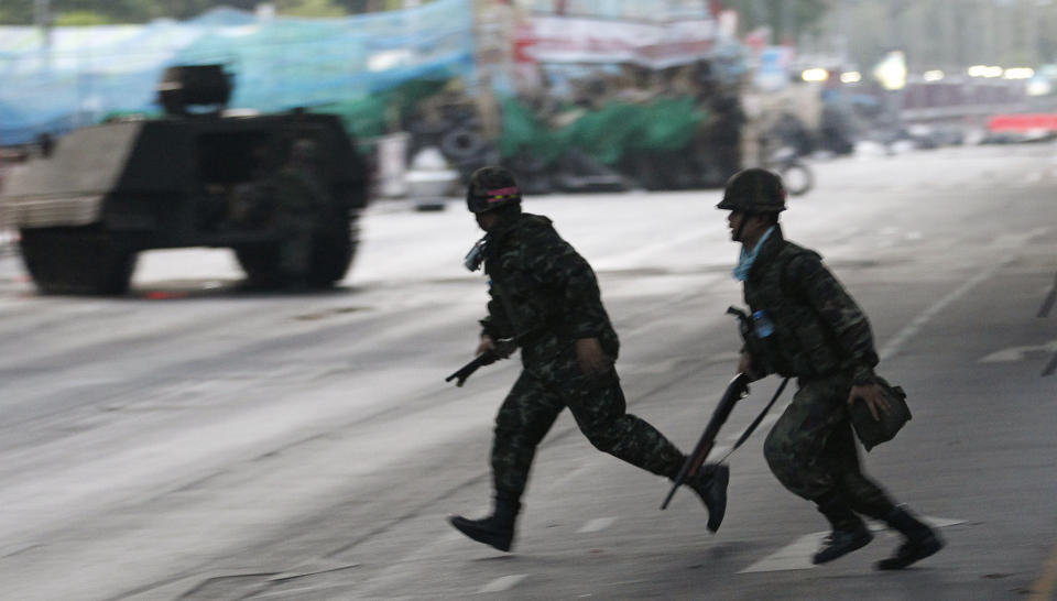 OPPT�YER: Soldater l�per forbi et pansret personellkj�ret�y i sentrum av Bangkok onsdag. Foto: REUTERS/SCANPIX