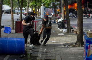MANGE SKADDE: To demonstranter hjelper en skadd person. Foto: REUTERS/Adrees Latif/SCANPIX