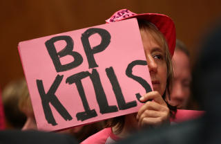 H�RINGER: Amerikanske myndigheter mener oljegiganten BP ikke forteller hele sannheter. Her er fra en h�ring i senatet der en demonstrant holder opp en plakat med teksten BP KILLS - BP DREPER.   Foto: Win McNamee/Getty Images/AFP/Scanpix