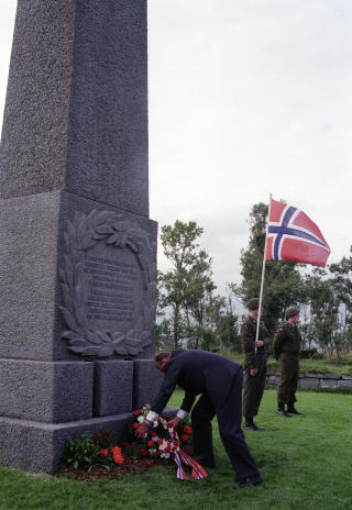 BLE FLYTTET HIT: I f�rste omgang gravde de opp cirka 4.500 lik i Nord-Norge for � flytte dem til en kjempestor kirkeg�rd i Tj�tta, s�r for Sandnessj�en. 
Her legger Kong Harald ned en krans p� krigskirkeg�rden p� Tj�tta 1992. Foto: TERJE BENDIKSBY/SCANPIX