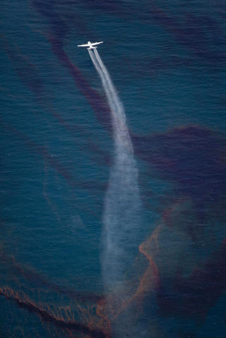 L�SER OPP OLJE MED KJEMIKALIER:  Et fly slipper kjemikalier over oljeflakene. Foto: SCANPIX/REUTERS/Handout/Daniel Beltra/Greenpeace