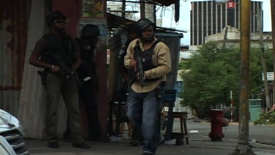 DE FATTIGES ROBIN HOOD: Jamaicansk politi i sivil jakter p� narkokongen Christopher �Dudus� Coke i Tivoli Gardens, en fattig slum der han har sitt hovedkvarter og sin tilhengerskare blant fattige, som ser p� ham som en velgj�rer. Foto: AP Photo/APTN/SCANPIX