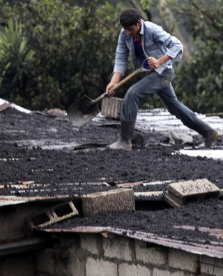 RENGJ�R: En mann rengj�r taket sitt etter vulkanutbruddet.  Foto: Daniel LeClair/REUTERS
