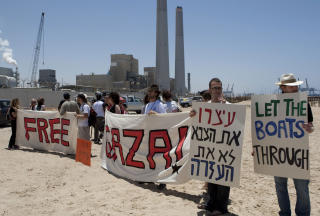 DEMONSTRANTER: Fredsaktivister fra Israel og utlandet st�r utenfor havneomr�det i Ashdod med plakater i dag. Foto: JACK GUEZ/AFP