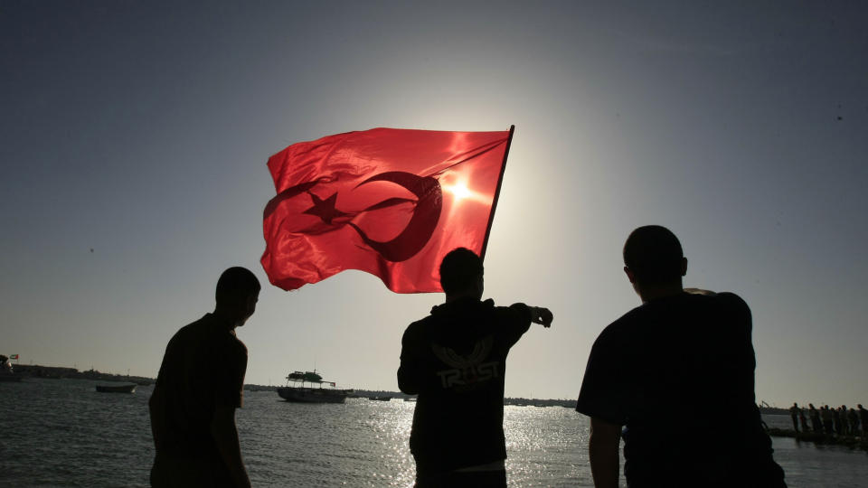 S�RGER OVER DE D�DE: Palestinere i Gaza City holder opp et tyrkisk flagg i sympati med de drepte p� skipene den 31. mai. Bordingen var et brudd p� internasjonal lov, og Israel brenner stadig flere broer overfor naboer og allierte skriver FAFO-forskerne i kronikken. Foto: AFP