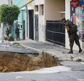SKUMMELT: En soldat kikker ned i det skremmende hullet. Foto: REUTERS/Daniel LeClair