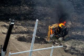  SP�R F�RST, GRAV SIDEN:  Gravemaskinen som gravde hull p� gassledningen i brann etter eksplosjonen. FOTO: AP/SCANPIX.