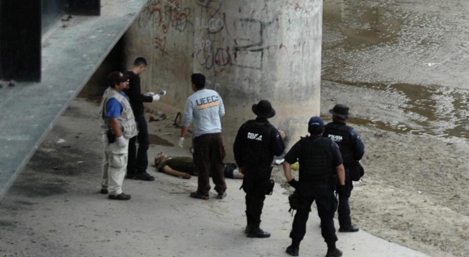 KASTET STEIN: Mexicansk politi unders�ker stedet der 15 �r gamle Sergio Adrian Hernandez Huereca ligger skutt og drept under grensebroen Paso Del Norte i Ciudad Juarez. Foto: AP Photo/SCANPIX