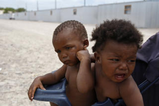 F�DT INN I FATTIGDOM: To sm�barn p� armen til mamma utenfor skurene i Blikkiesdorp. Foto: AP/Schalk van Zuydam/Scanpix
