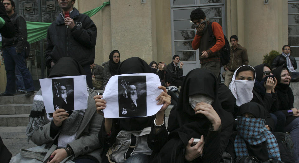 FARLIG: Regimekritiske demonstranter dekker ansiktene sine under en demonstrasjon ved universitetet i Teheran i desember i fjor. Etter at bildet ble tatt, rev de i stykker bildene av Ayatollah Khomeini, Irans f�rste leder etter revolusjonen i 1979. Det er forbundet med livsfare � demonstrere mot regimet. Foto: AP