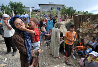 STENGTE GRENSEN: Usbekere p� grensen mellim Kirgisistan og Usbekistan venter p� � f� krysse. Usbekistan stengte i dag grensene etter en masseflukt av Usbekere over grensen.Foto: AFP PHOTO / VIKTOR DRACHEV
