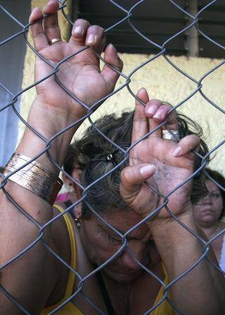 P�R�RENDE: En p�r�rende fors�ker � f� informasjon om sin kj�re utenfor Mazatlan-fengselet i Mexico. Foto: AP