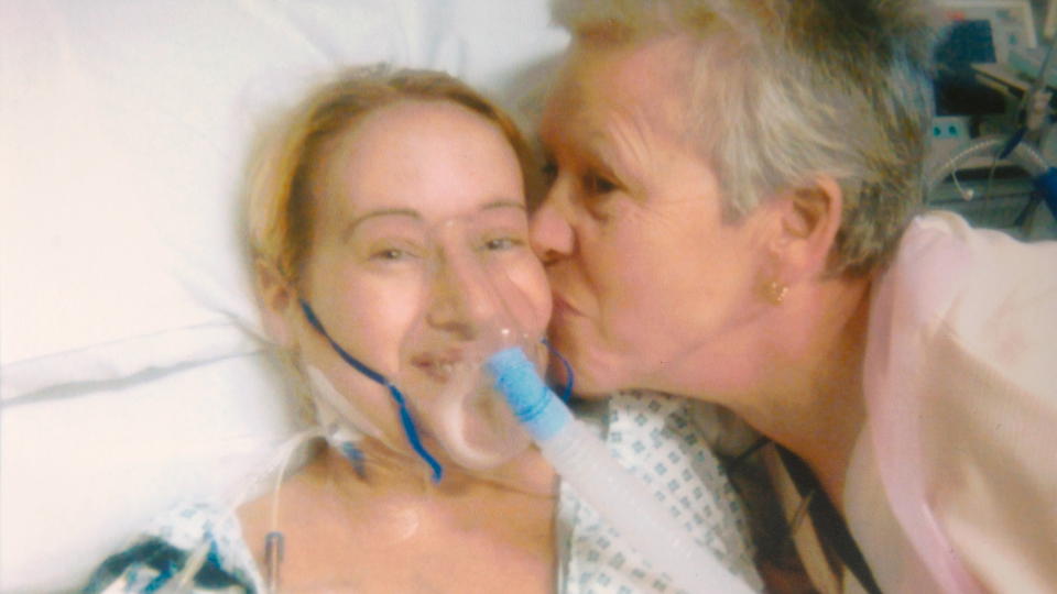 SMILTE: Lindsay Scott har p� seg en oksygenmaske etter lungetransplantasjonen og f�r et kyss p� kinnet fra mamma. Hun fikk aldri vite at lungene hun fikk var fra en storr�yker gjennom 30 �r. Foto: Cavendish Press