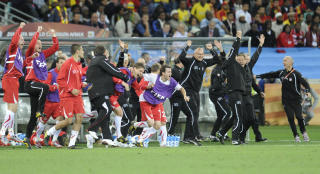 HER LYDER SLUTTSIGNALET: Og sveitserne stormer banen i lykke. Foto.  AFP PHOTO / LIU JIN