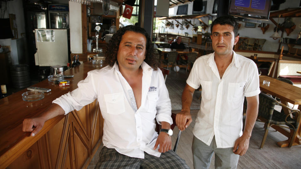 TRIST:  Murat Kocat�rk (t.v.) og Mehmet Ceylan ved Kingfisher Pub i Side har nesten ingen gjester lenger. Gjestene spiser seg heller mette p� all inclusive-hotellene i nabolaget. Foto: Eivind Pedersen