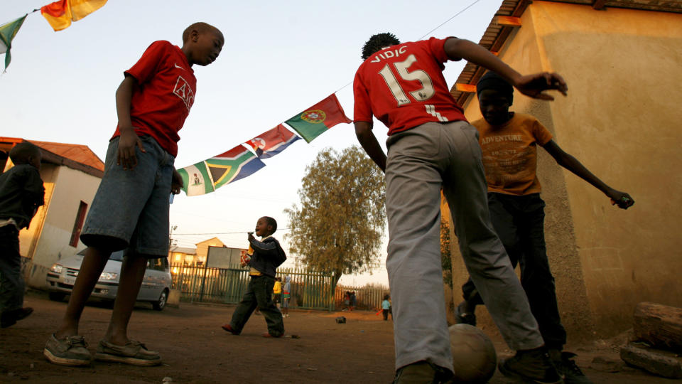 DU KAN HJELPE: Barna spiller fotball f�r g�rsdagens m�te mellom S�r-Afrika og Frankrike i VM. N� kan du ringe 820 400 40 og gi 25 kroner - en kaffekopp - til arbeidet i Kliptown. Foto: Wayne Conradie