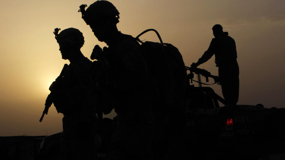  LANGT TIL LYS:  Amerikanske soldater p� vei til inspeksjonsoppdrag i Maruf-Kariz i Dand-regionen mens sola er i ferd med � st� opp l�rdag. FOTO: REUTERS/SCANPIX.