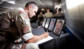 S�RGER: Medsoldater signerer en kondolanseprotokoll for de falne i Mazar-e Sharif. Foto: Forsvaret