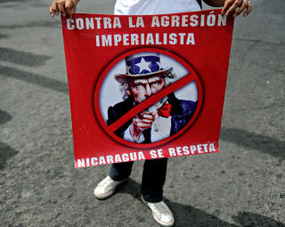 ANTI-IMPERIALISTISK: En sandinist-st�ttespiller med antiamerikansk plakat. Men sandinistene har stemt for en frihandelsavtale med USA og er venner n�r det trengs. Foto: AFP/Elmer MARTINEZ