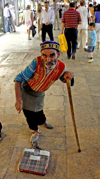 LEVEBR�D: Denne halvblinde mannen har skapt sin egen arbeidsplass i en av de travleste gangene i Grand Bazaar - det koster 50 �re � veie segp� badevekta hans - og 20 kroner � ta bilde!