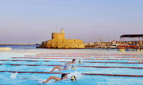 RHODOS: Byen Rhodos har v�rt bebodd i  2400 �r  med en fin blanding av Europas best bevarte gamleby og en hektisk nyby. Vannpoloteamet til Nautical Club of Rhodos trener ved  Mandrakihavna.