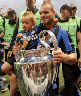 MESTER: Wesley Sneijder med Champions League-trofeet i den ene armen og s�nnen Jessey p� den andre. Foto: EPA