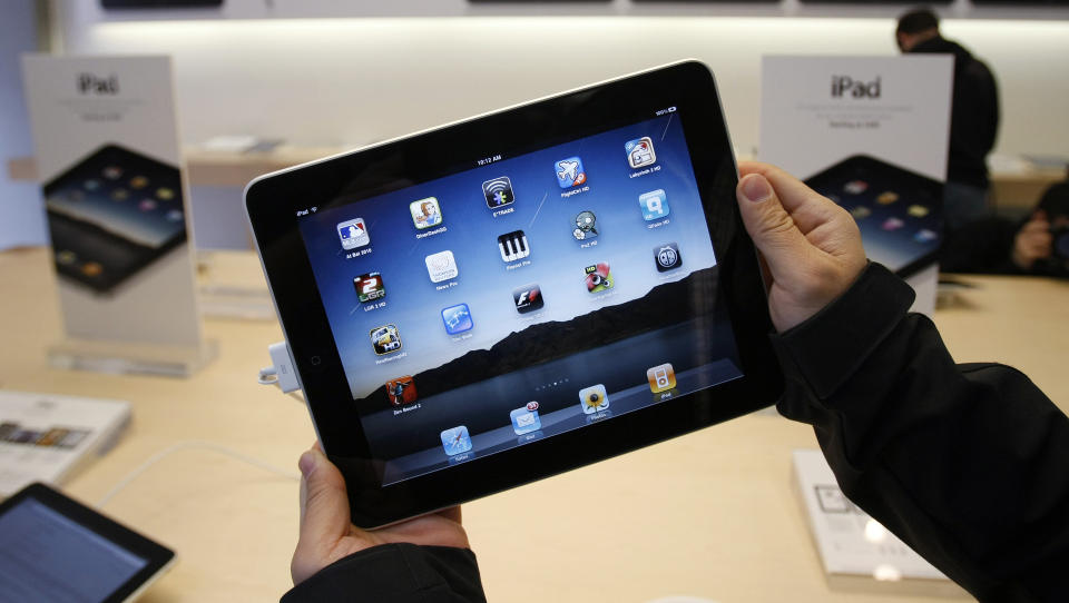 DISKRET: Med en iPad eller et annet lesebrett i fanget, kan du enkelt skjule hvilken bok du leser for gjengen p� nabobordet. Foto: SCANPIX / AP /Paul Sakuma