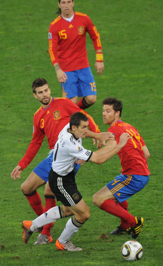 FOTBALLSMART: Xabi Alonso rydder opp sammen med Pique under semifinalen mot Miroslav Klose og Tyskland. Foto: AFP