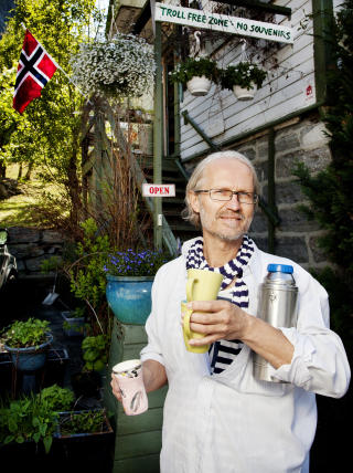 INGEN TROLL: Turistene st�r i k� for � ta bilde av skiltet utenfor Ola Lilands galleri. Men selv uten suvernirer tjener han godt p� sommergjestene. S� reiser han bort.
