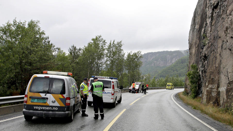 Mannskaper fra Vegvesenet, politi og ambulanse p� stedet der en person d�de etter at bilen han satt i ble truffet av et steinras p� E39 i S�gne kommune i Vest-Agder s�ndag ettermiddag. Foto: Tor Erik Schr�der / SCANPIX