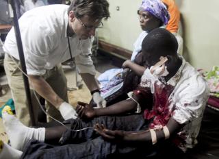 S�RET: En s�ret mann f�r behandling av en FN-lege p� sykehuset Mulago i Ugandas hovedstad Kampala, etter bombeangrepet i g�r kveld. FOTO: EPA