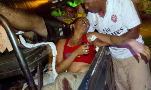 SKADD KVINNE: En mann fors�ker � hjelpe en kvinne som ble skadd i bombeangrepet i Uganda i g�r kveld. AP Photo/Marcv Hoafer