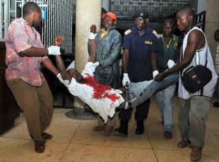 B�RES TIL SYKEHUS: En s�ret mann er framme ved et sykehus i Kampala etter bombeattentatene mot VM-fans i byen s�ndag kveld. Foto: AFP / STRINGER