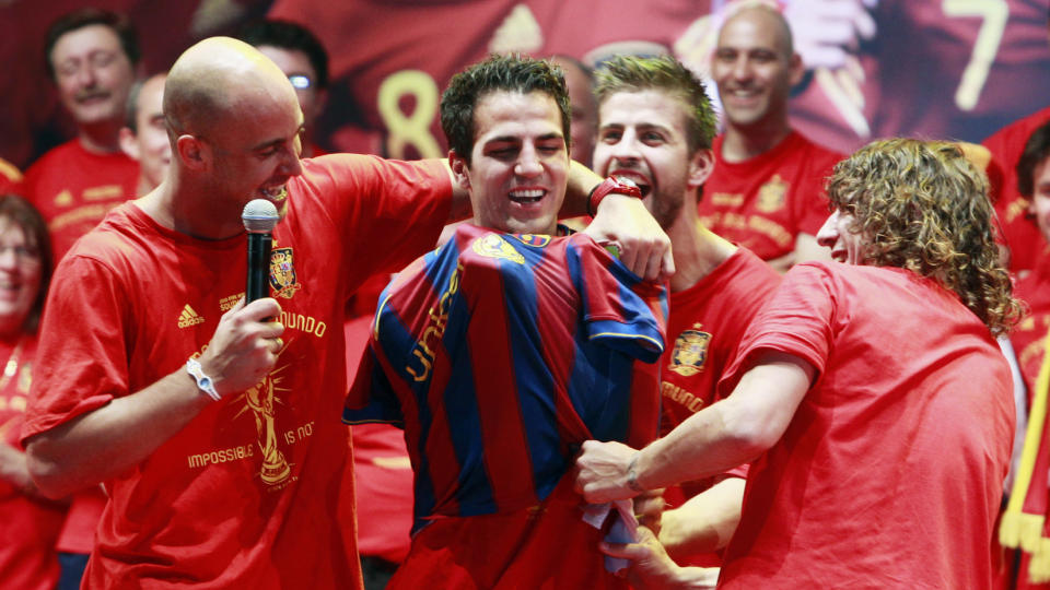SPEKULASJONER: Carles Puyol dro p� Fabregas en Barca-tr�ye da de spanske spillerne feiret VM-gullet. Barcelona-kapteinen har v�rt en av de ivrigste til � g� ut offentlig og helle bensin p� overgangsb�let til Fabregas, n� ber Wenger sin egen kaptein om � slukke det. Foto: AFP