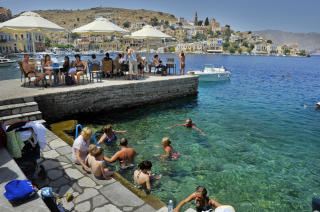  BYBADING:  En avkj�lende dukkert utenfor fortauskafeene p� Symi.  Foto: JOHN TERJE PEDERSEN
