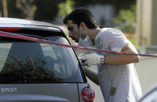 ETTERFORSKER: En politietterforsker leter etter bevis utenfor hjemmet til den 37 �r gamle greske journalisten. Foto: REUTERS/Icon/Panagiotis Tzamaros