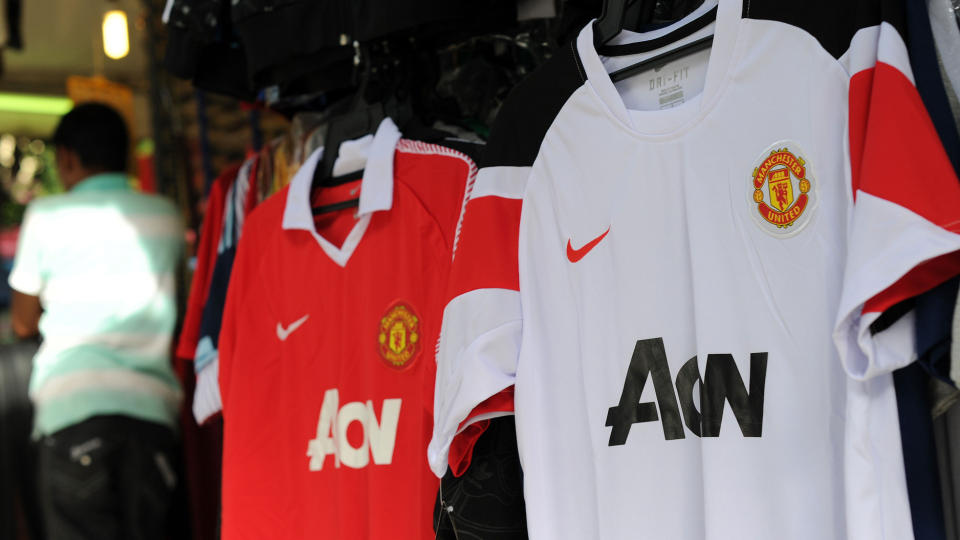 SELGES I ASIA: Her henger United-tr�yene utenfor en butikk i Kuala Lumpur. En religi�s leder vil ha slutt p� salget av draktene med en djevel i klubblogoen. Foto: AFP/Saeed KHAN