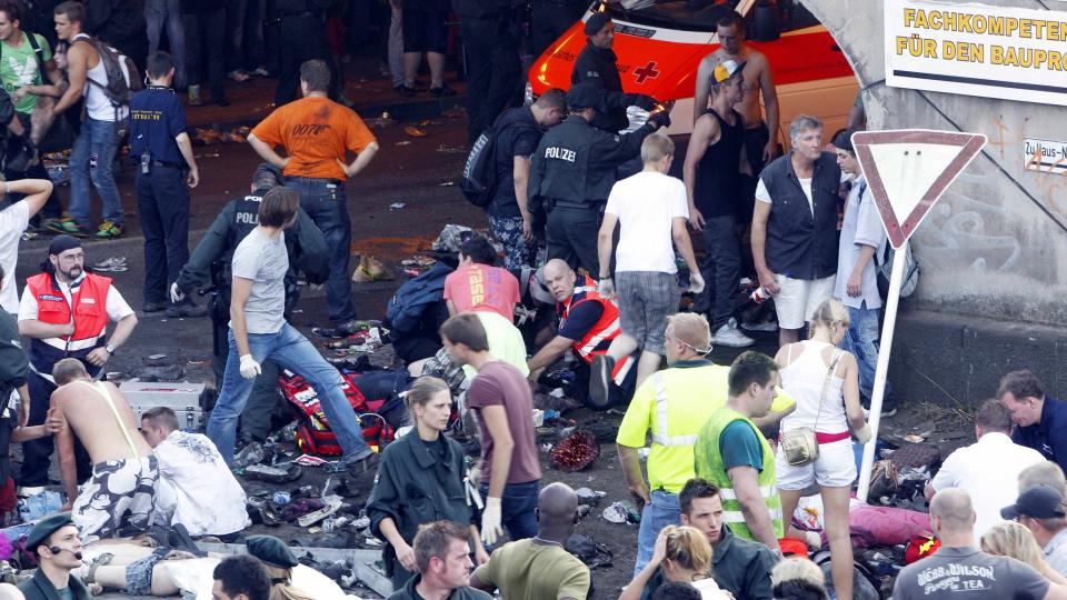 TRAGEDIE: Store redningsmannskaper pr�vde � f� oversikt etter at det oppsto panikk i trengselen ved en tunnel da Love Parade bevegde seg gjennom den. Foto: SCANPIX