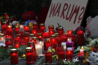 HVORFOR? Flere tente lys for de d�de i dag. Mellom bamser, kort, blomster og lys, ble dette skiltet satt opp med den tyske p�skriften: Hvorfor? FOTO: AP/dapd/Mario Vedder