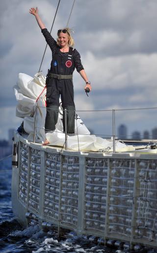 PLASTIKI:Skipper Jo Royle, p� plastflaskeskipet vinker n�r den spesielle farkosten ankommer Sydney. Foto: EPA/PAUL MILLER