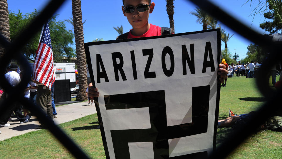 PROTESTERER: En ung gutt protesterer sammen med andre demonstranten mot Arizonas t�ffe innvandringslov i Phoenix 29. mai i �r. Aktivistene mener den nye loven vil �pne d�rer for et rasistisk politi, mens tilhengerne av loven har understreket at ordlyden i loven forbyr politiet � stoppe noen kun basert p� deres etnisitet. Foto: Mark Ralston/AFP Photo.