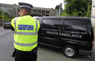 KRIMINALSAK: En politimann passer p� n�r en ambulanse kj�rer bort fra �stedet ved Slateford Road i Edinburgh Foto: REUTERS/David Moir