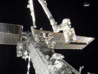SLO HODENE SAMMEN: De to astronautene hadde lite arbeidsrom, og sto s� tett at hjelmene st�tte sammen. Foto: NASA TV
