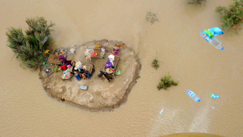 FLOMKATASTROFE I PAKISTAN: Millioner av mennesker rammes av flommen i Pakistan. P� bildet ser man barn og voksne som klamrer seg til en liten �y i flomvannet i den pakistanske byen Sukkur. Foto: AFP PHOTO/ASIF HASSAN