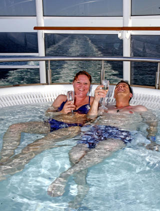 CRUISEF�LELSE: Hva gir st�rre cruisestemning enn � nyte et glass champagne i badekulpen, med skipets kj�lvannsstripe tegner seg snorrett p� bl�tt hav?