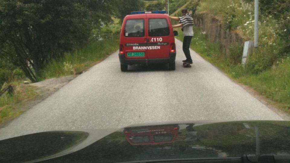 HAIK: Mannen p� rullebrett holder fast i brannbilen. Foto: Nanje Leikanger