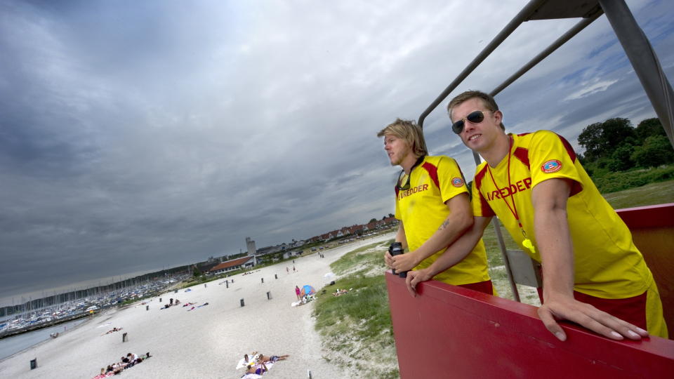 SKRYTER AV KOMPISEN: Jobben som livredder berget trolig livet til danske S�ren Thuesen (24) (t.v.) etter g�rsdagens b�tforlis ved Mandal. - Han er en fighter, sier kompis og livredderkollega Steffen S�ndergaard. Her er de avbildet i sommer under en vakt p� Nordstranden ved Kerteminde. Foto: J�RGEN HANSEN/Fyens Stiftstidende